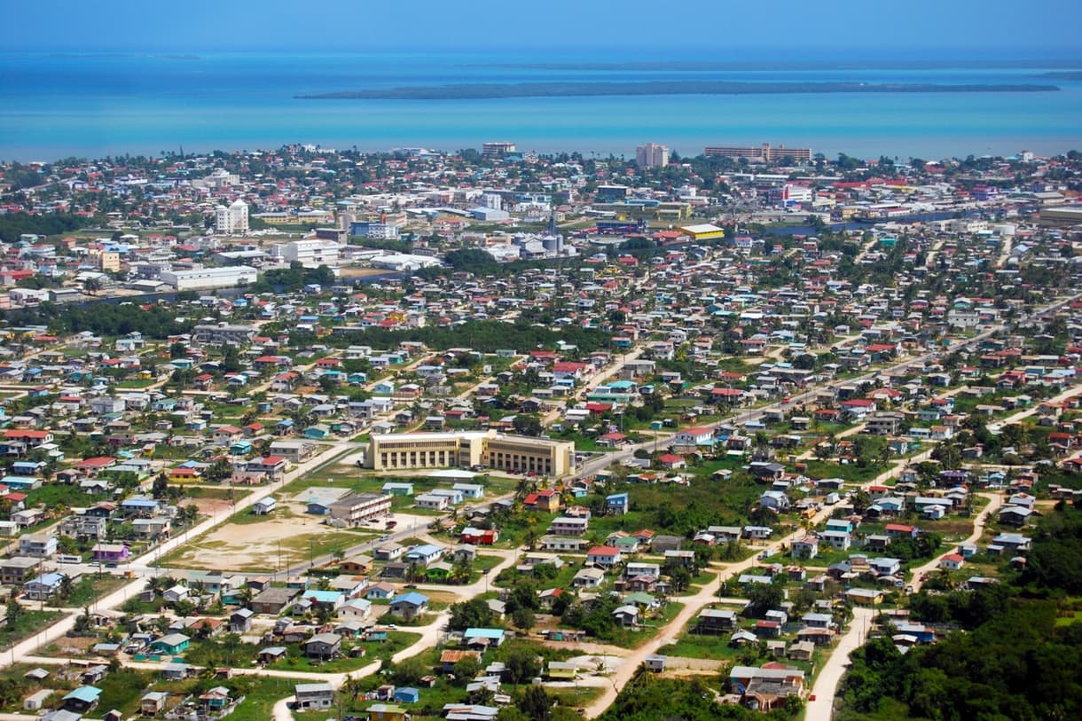 Vue aérienne de Belize City, montrant des quartiers résidentiels et la mer au loin.