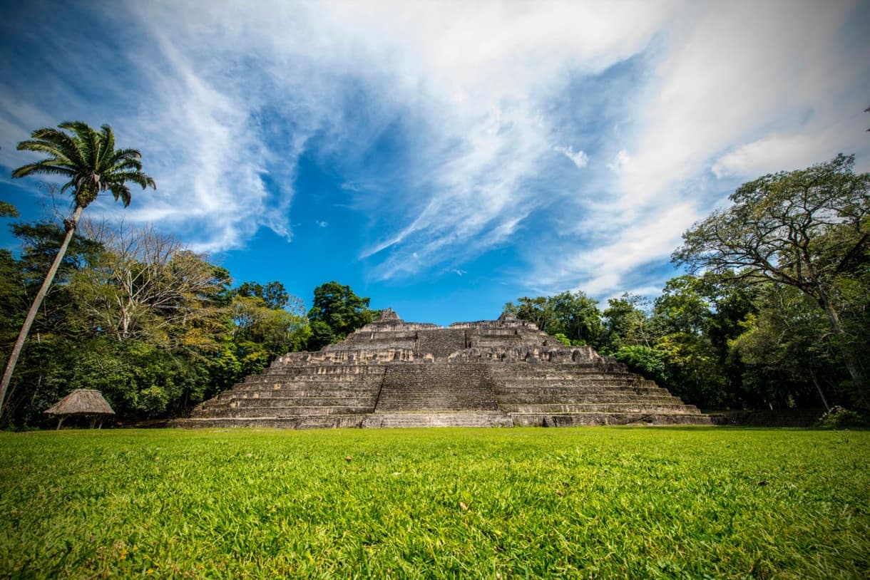 Cité de Caracol au Belize, pyramide majestueuse entourée de verdure et ciel bleu