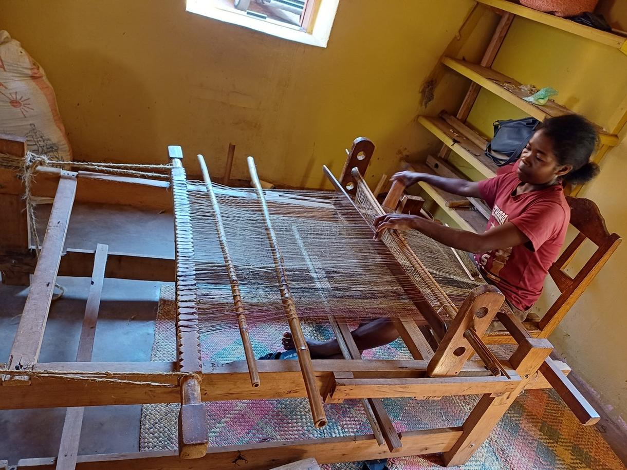 Artisan tissant sur un métier à tisser dans un atelier lumineux