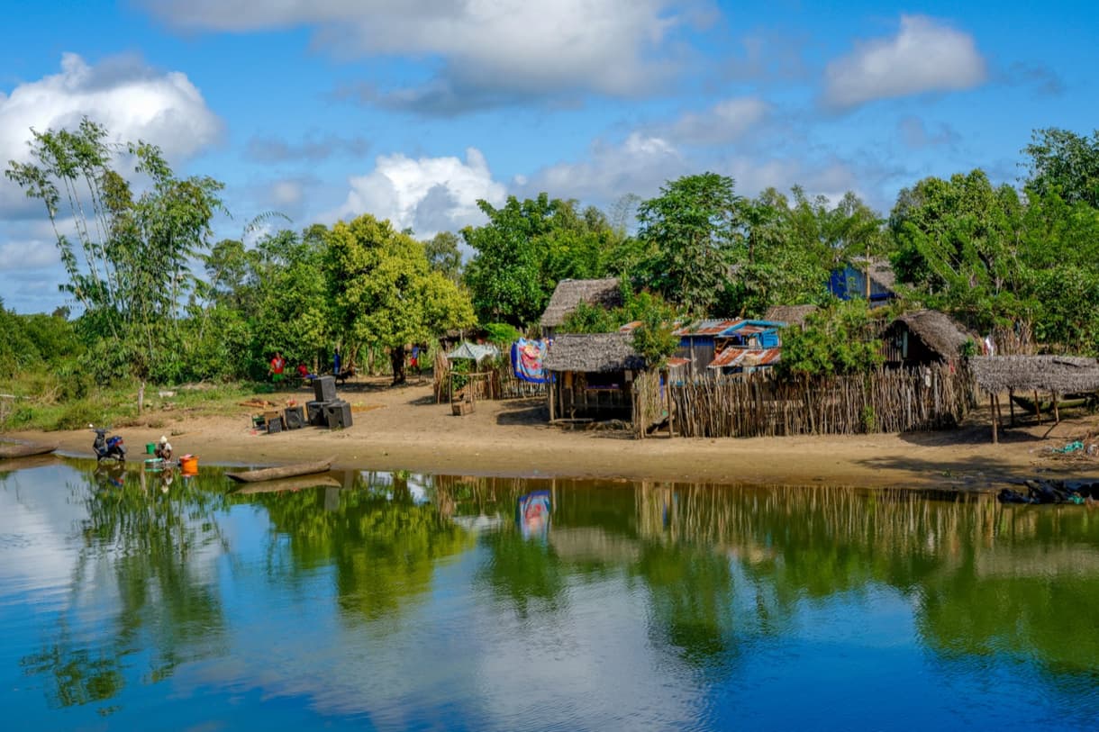 Canal des Pangalanes avec village et végétation luxuriante au bord de l'eau