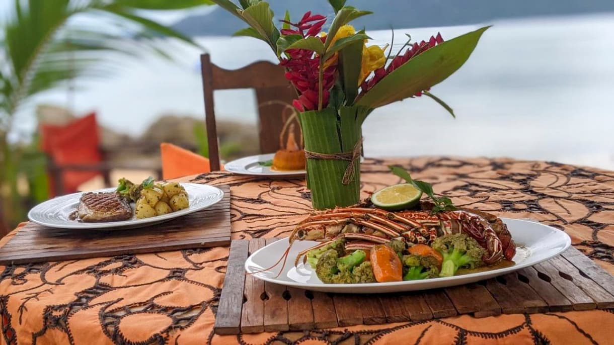 Plat de fruits de mer frais sur une table avec vue sur l'océan à Nosy Komba, Madagascar