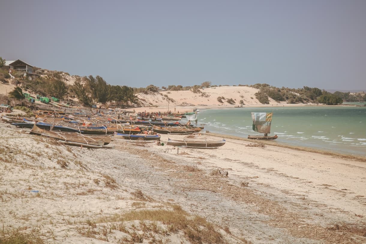 Plage d'Ifaty, Madagascar, avec des bateaux de pêche et des dunes en arrière-plan
