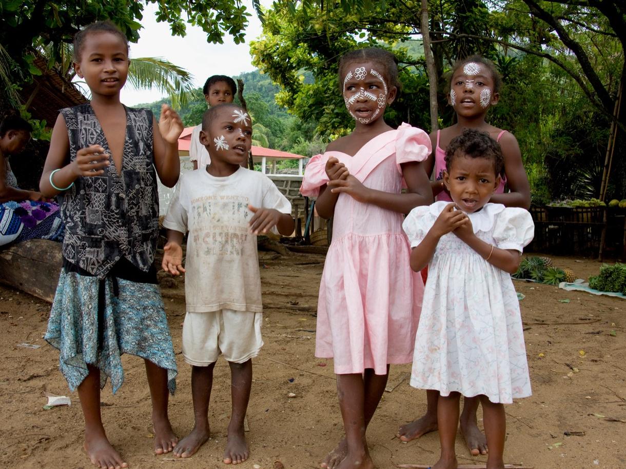 Enfants à Nosy Komba, maquillés, jouant sur une plage.