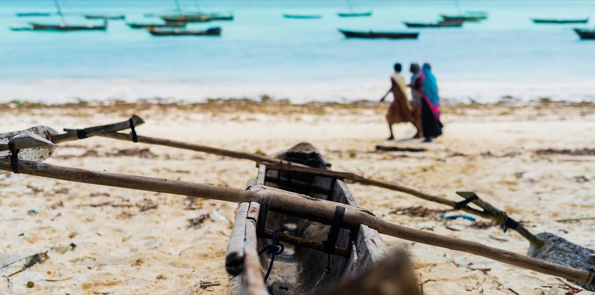 Plage d'un village de pêcheurs avec des embarcations en bois, ambiance tranquille