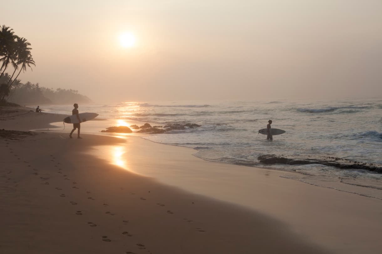 Arugam Bay, Sri Lanka : plage au lever du soleil avec surfeurs, palmiers et vagues