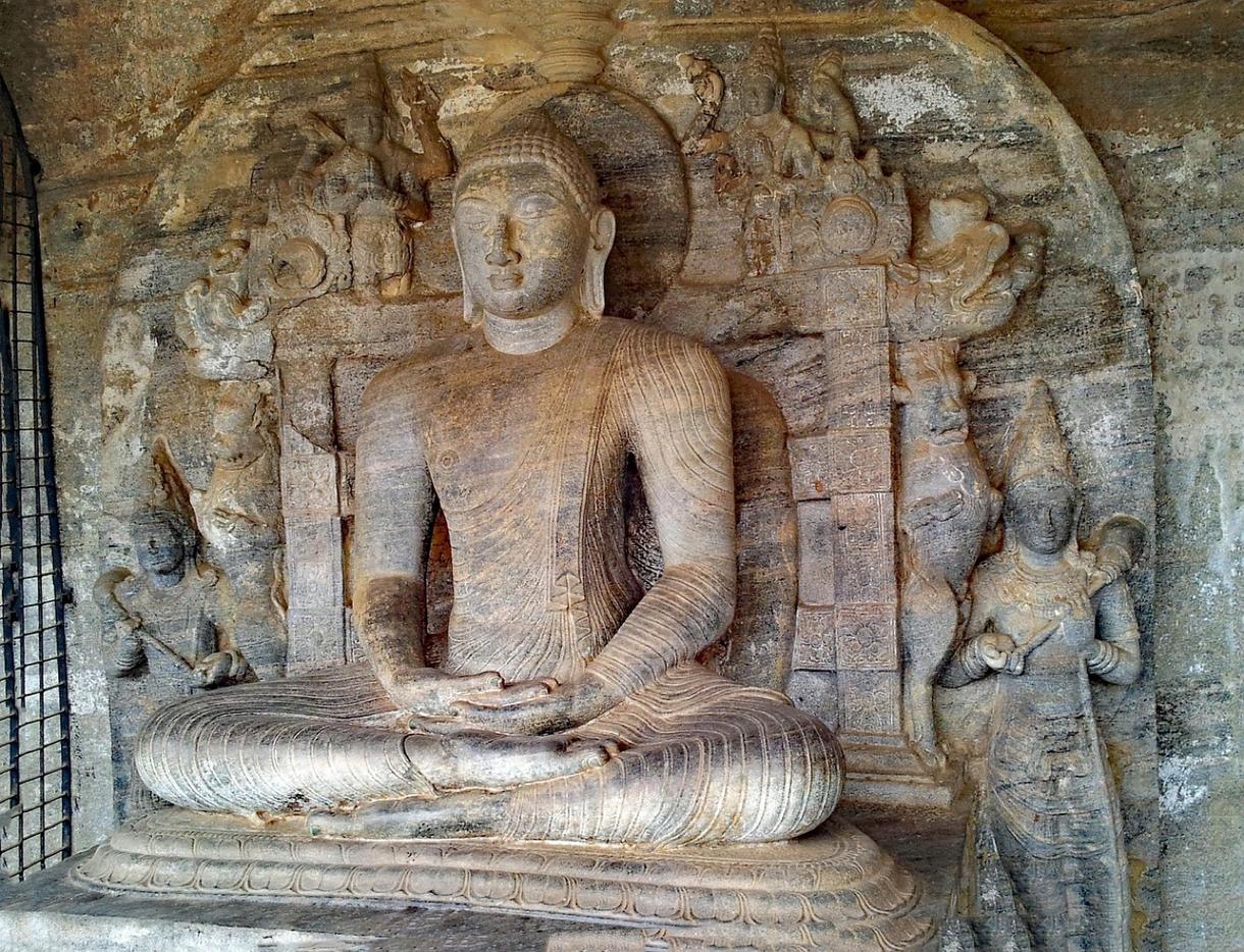 Statue de Bouddha à Polonnaruwa entourée de sculptures historiques