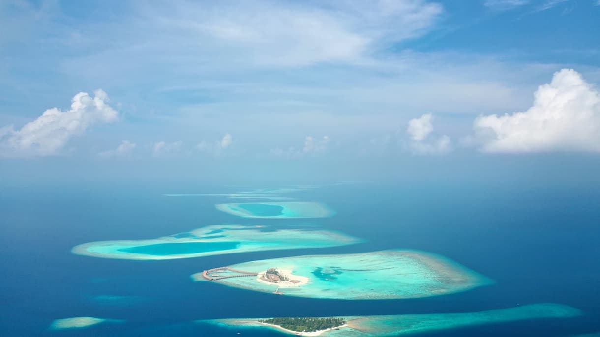 Vue aérienne des îles maldiviennes avec lagons turquoise et ciel dégagé