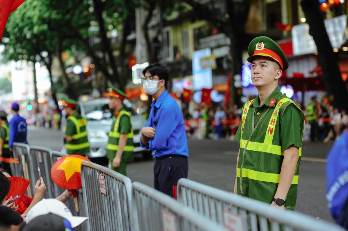 Agents de police en uniforme surveillant une rue animée au Vietnam pendant un événement