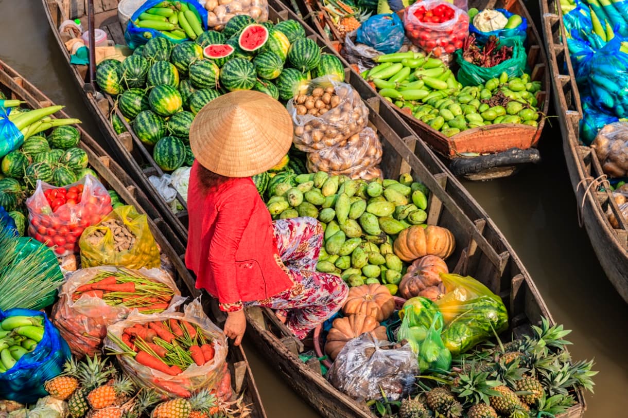 Marché flottant dans le delta du Mékong avec fruits et légumes variés