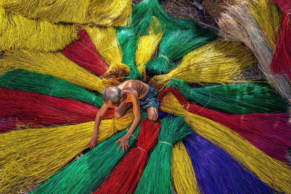 Artisan vietnamien travaillant avec des fibres colorées, Centre du Vietnam.