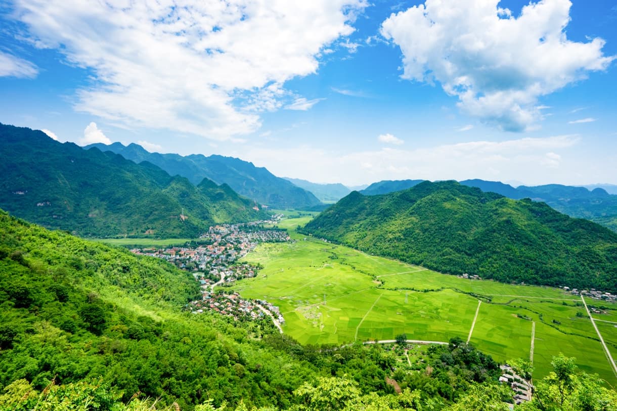 Vallée de Mai Chau, paysages verdoyants, rizières et montagnes sous un ciel bleu