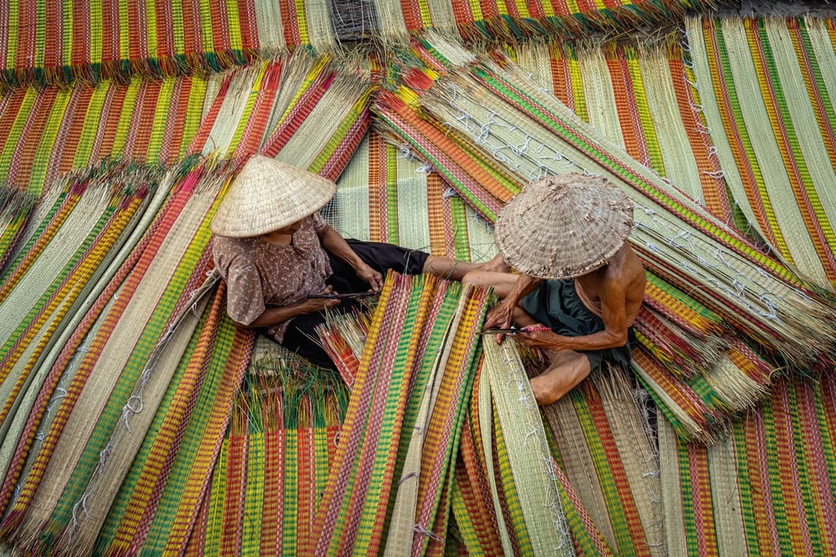 Artisans vietnamiens tissant des nattes colorées, ambiance traditionnelle et artisanale